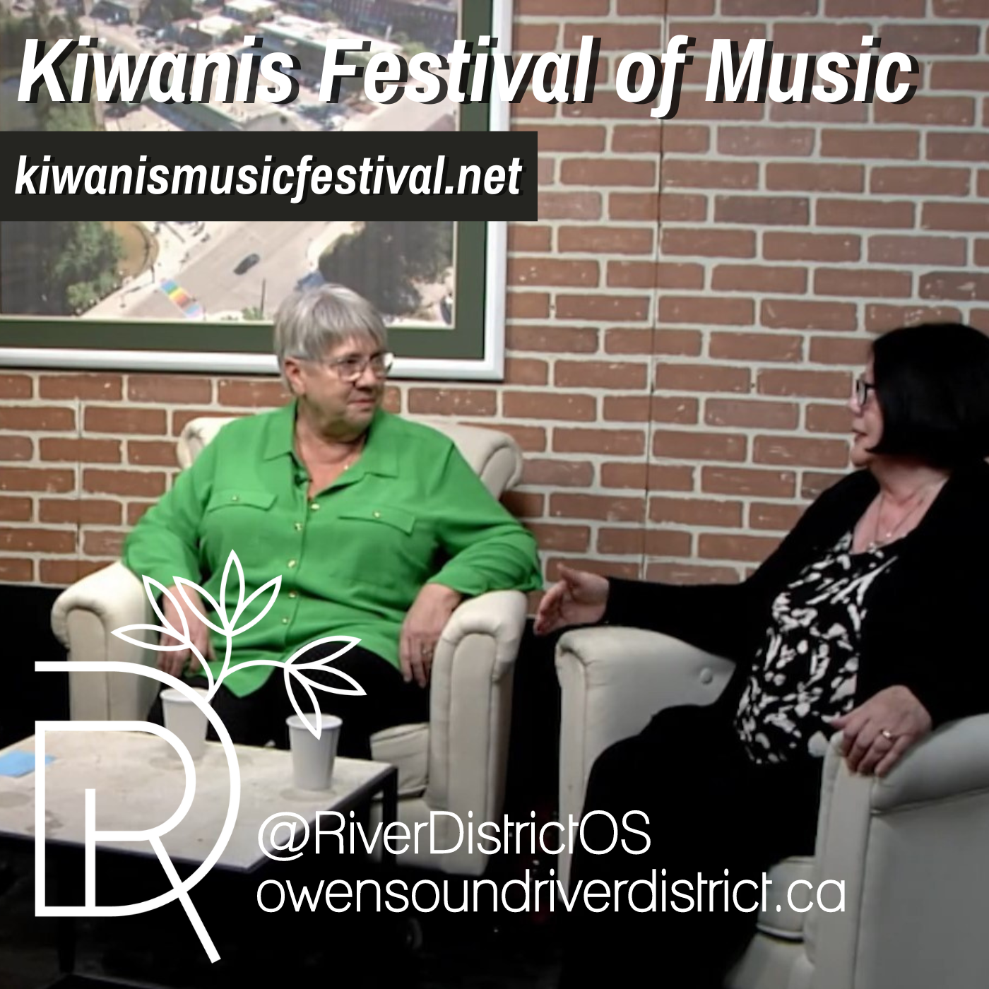 Linda Van Aalst & Linda Hawkins sitting in white chairs against a faux brick background and large white framed image